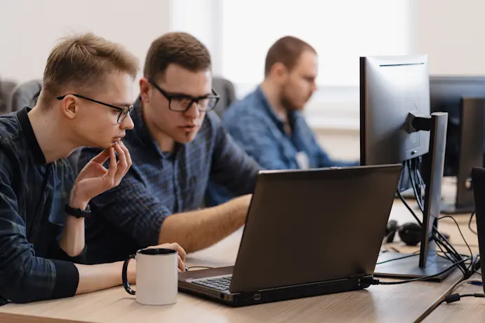Két férfi egy laptopnál egyeztet